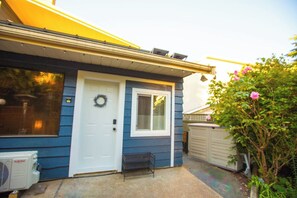 Ett bostadshus med en ytterdörr, en liten veranda och ett garage.