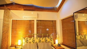 Un dormitorio con cama, mesitas de noche, un espejo y una ventana con persianas.