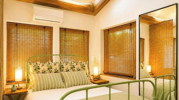 Una habitación con una cama, mesitas de noche y un espejo.