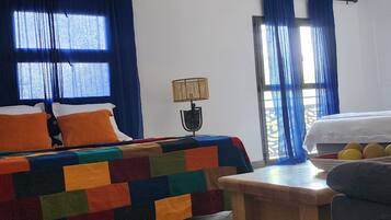 Una camera d'albergo con un letto, un tavolo, una lampada e vista sull'esterno.