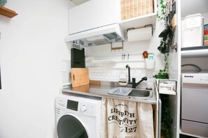 Una cucina compatta con lavatrice, lavandino e forno Danby.