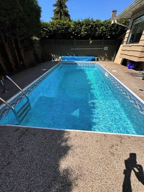 A rectangular swimming pool with a ladder on one side, surrounded by a concrete deck. - Chic Artistic Suite Cozy Luxury w private entry (Richmond)
