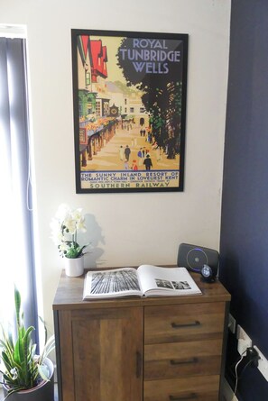 A framed vintage poster of Royal Tunbridge Wells, a guide-free, town hall, and Southern Railway trains.