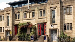 A historic building with 'Public Baths' signage, featuring a central entrance with red doors, a staircase, and a covered upper level. - Comfortable 3BR Townhouse for 6 (London)