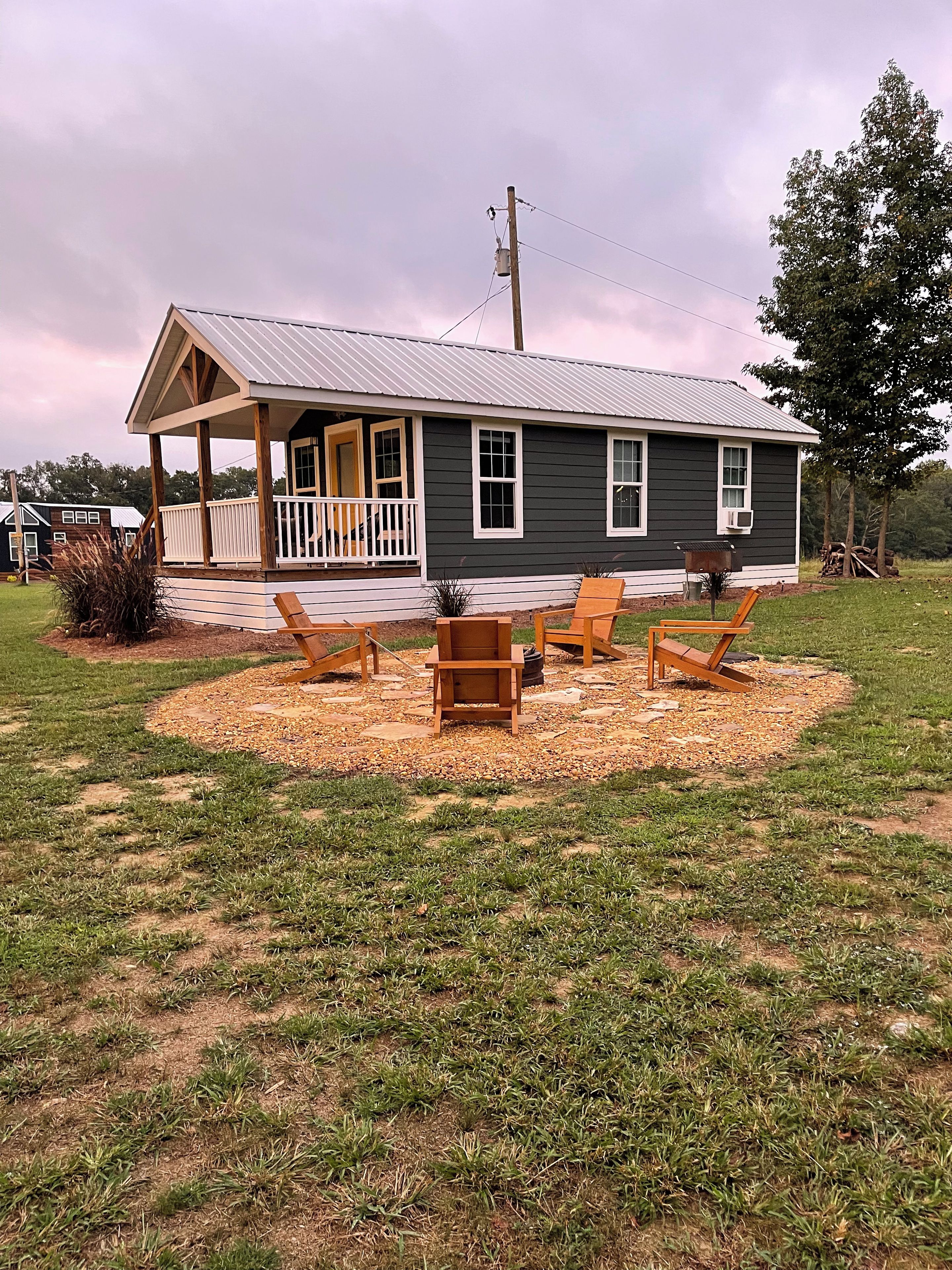 A house with a porch, a small deck, and outdoor seating.