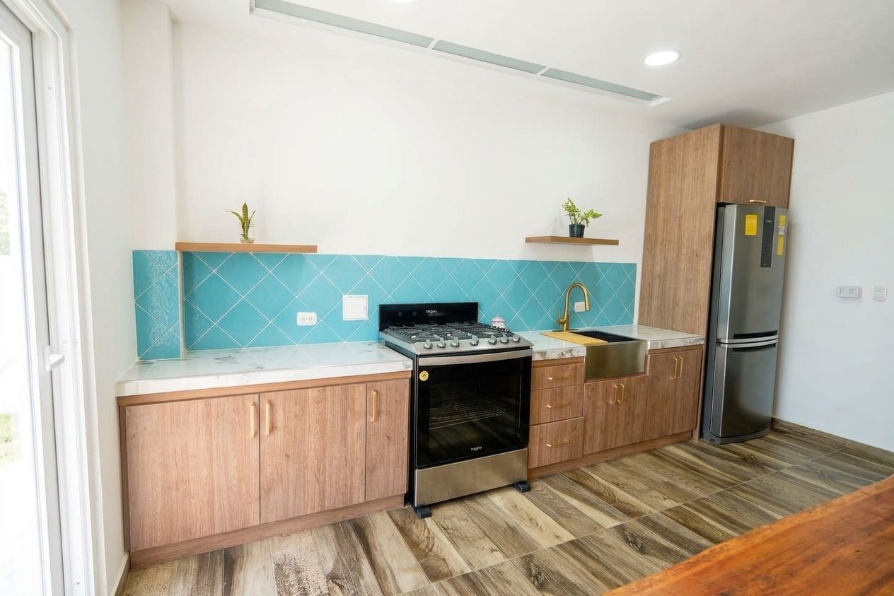 Una cocina con armarios de madera, estufa de acero inoxidable, un lavaplatos y un refrigerador.