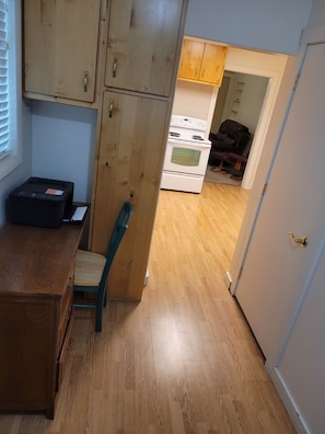A kitchen with wooden cabinets, a white stove, and a chair.