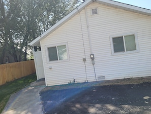 A single-story house with a front porch, a small attached garage, and a visible electrical box on the exterior wall.