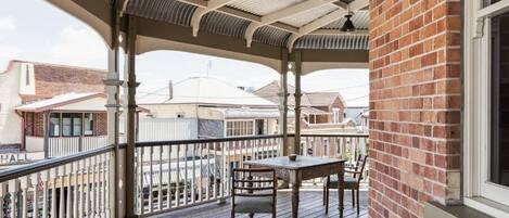 Un espace extérieur abrité, doté d’une terrasse en bois, d’une table et de chaises.