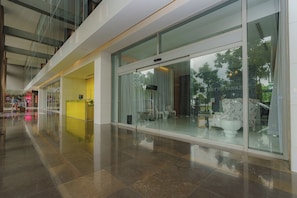 A modern interior with a glass storefront, a reception area, and a seating area with a view of the outdoors. - Elegant and Modern 1BR with Balcony in Yoo Panama (Panamá)