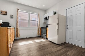Une cuisine compacte équipée d’un réfrigérateur, d’un four et d’un four à micro-ondes.