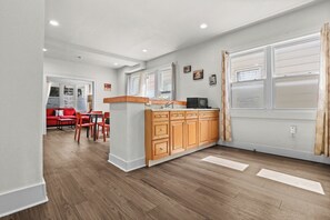 Une cuisine moderne avec des meubles en bois, un îlot central et un coin repas avec des chaises rouges.