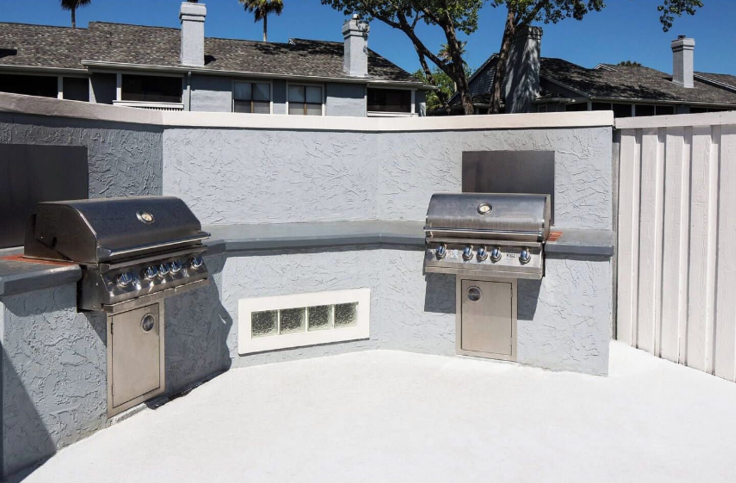 Un área de barbacoa al aire libre con dos parrillas a gas y un sistema de ventilación.