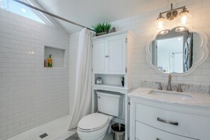 A bathroom with a shower, toilet, vanity, and a mirror with a decorative frame. - Private 1 Bedroom Guest House, White Rock Lake, just 10 min to Dtwn Dallas (Dallas)