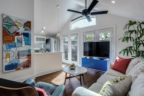 A modern living room with a ceiling fan, a dining area with a kitchen in the background, and a large abstract painting on the wall. - Private 1 Bedroom Guest House, White Rock Lake, just 10 min to Dtwn Dallas (Dallas)
