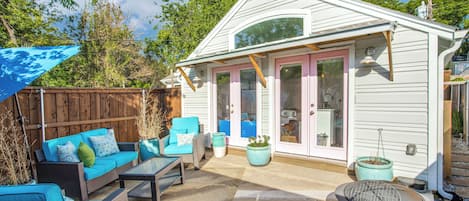 A house with a patio area featuring outdoor furniture, a fire pit, and a wooden fence.