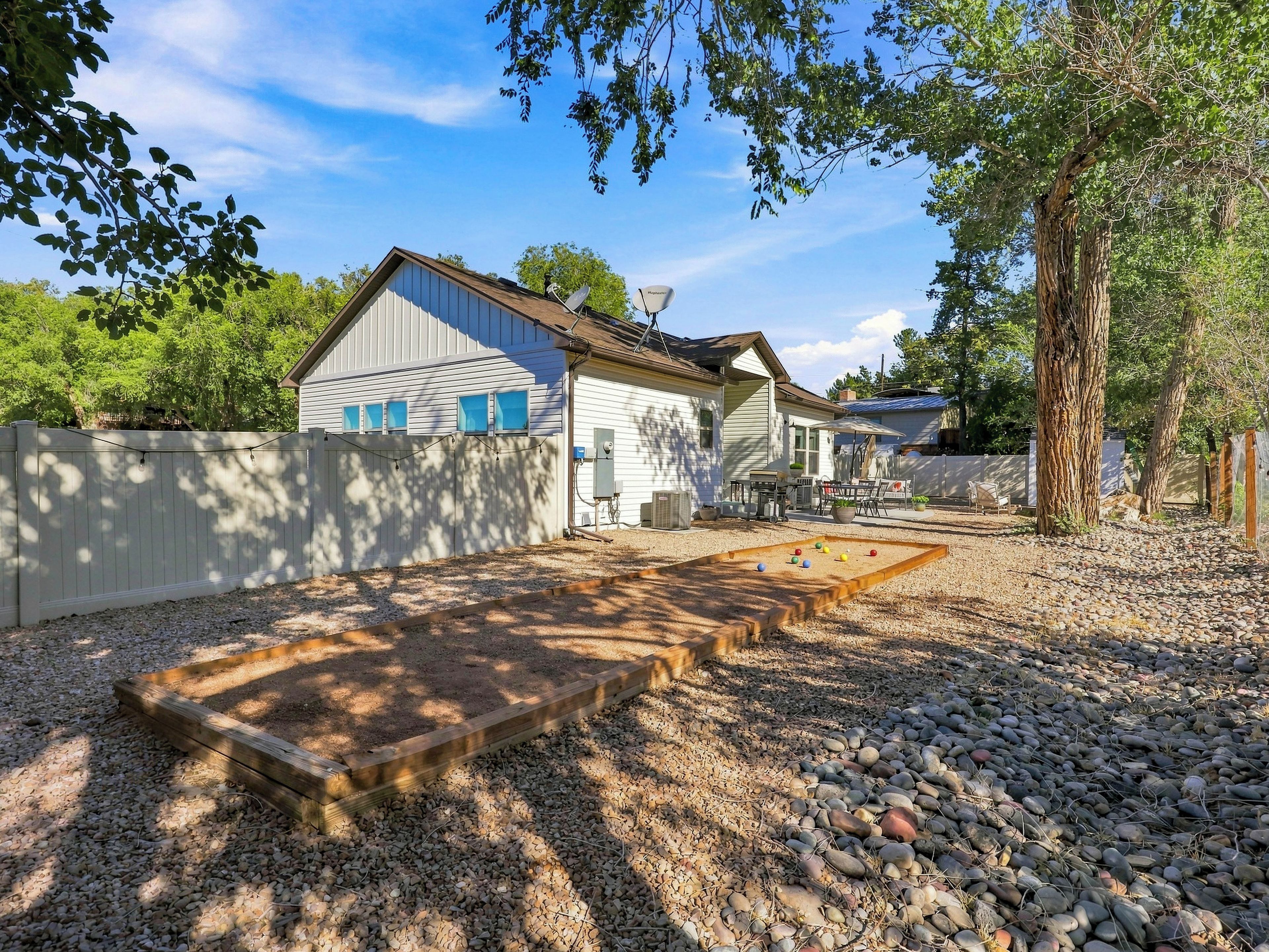 Ein Wohnhaus mit Terrasse, Holzdeck und umzäunter Garten.