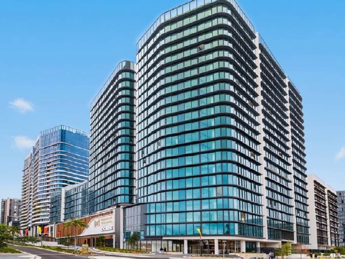 A modern high-rise building with multiple floors, large windows, and a curved facade.