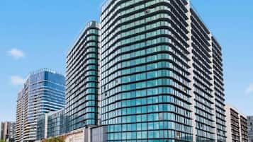 A modern high-rise building with multiple floors, large windows, and a curved facade.