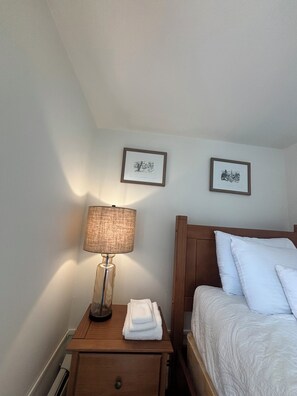A hotel room with a bed, a nightstand with a lamp, and two framed pictures on the wall. - 4BR Ski-Season Home: 8 Min to Okemo + Private Studio (Cavendish)