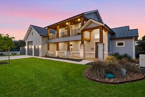 Une maison à deux étages avec un porche abrité, un garage et une pelouse bien entretenue.