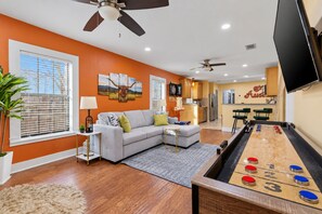A living room with a pool table, a sofa, and a television. - Austin Fun House Huge Private Yard, Pickleball, Cowboy Pool & Hot Tub (Austin)