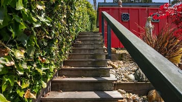 Betonnen trappen leiden omhoog naar een rood gebouw met een zwarte balustrade.