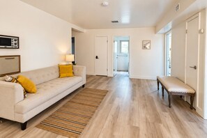 Ein modernes Wohnzimmer mit einer Couch, einer Bank und einem Teppich.
