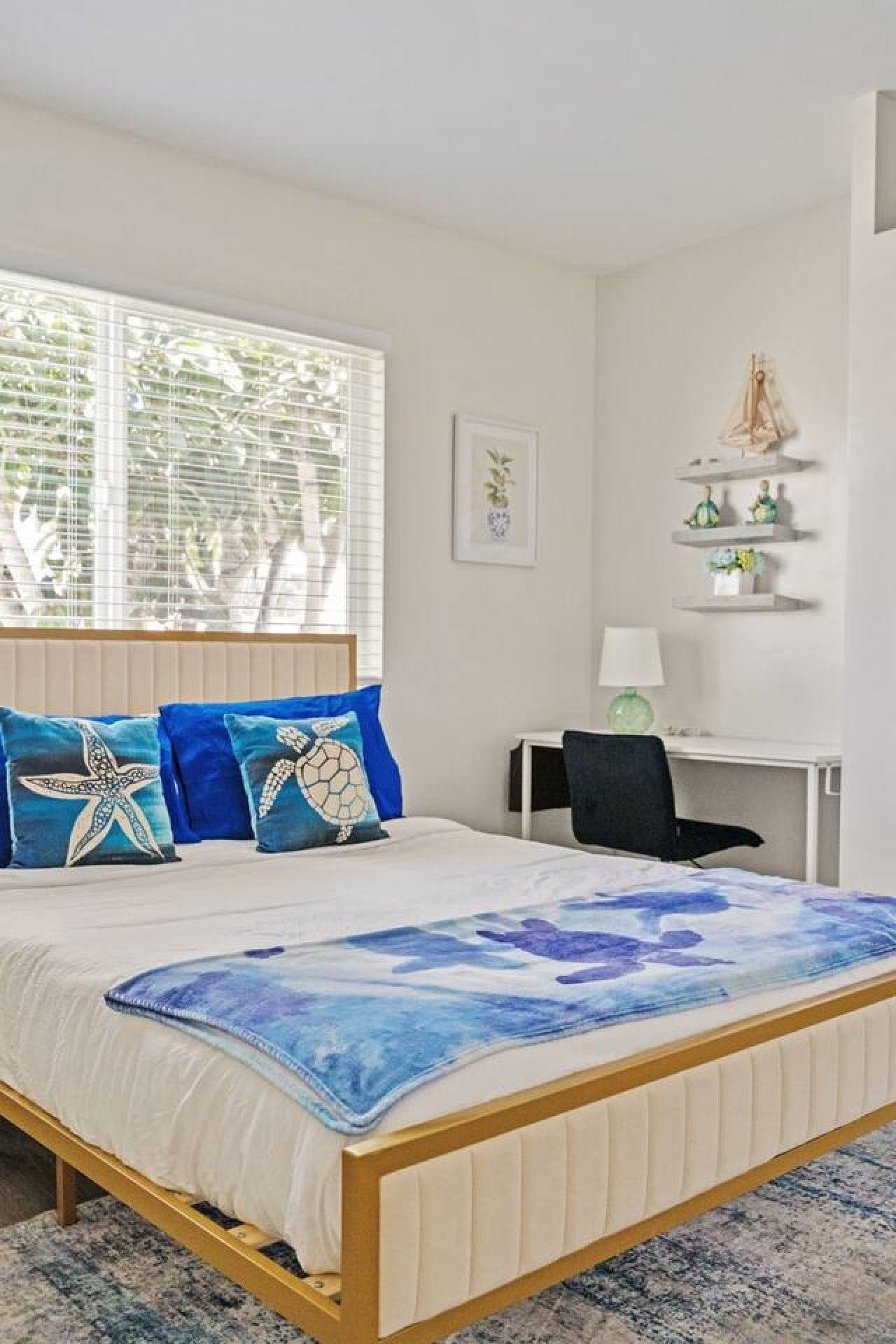 A bedroom with a bed, a desk, and a chair.