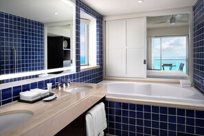 Un baño con una bañera grande, un lavabo doble y un espejo.
