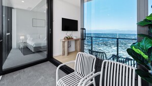 Habitació d'hotel moderna amb balcó, llit, televisió i vista a la ciutat.