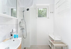 A modern bathroom with a shower, a sink, and a window. - Kazimierza Wielkiego Charming Studio (Kraków)