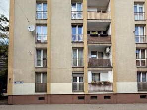 A multi-story residential building with balconies, satellite dish, and a visible address sign. - Kościuszki Central Apartment #7 (Wrocław)