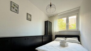 Una camera da letto con un letto, un armadio e una finestra con tende.