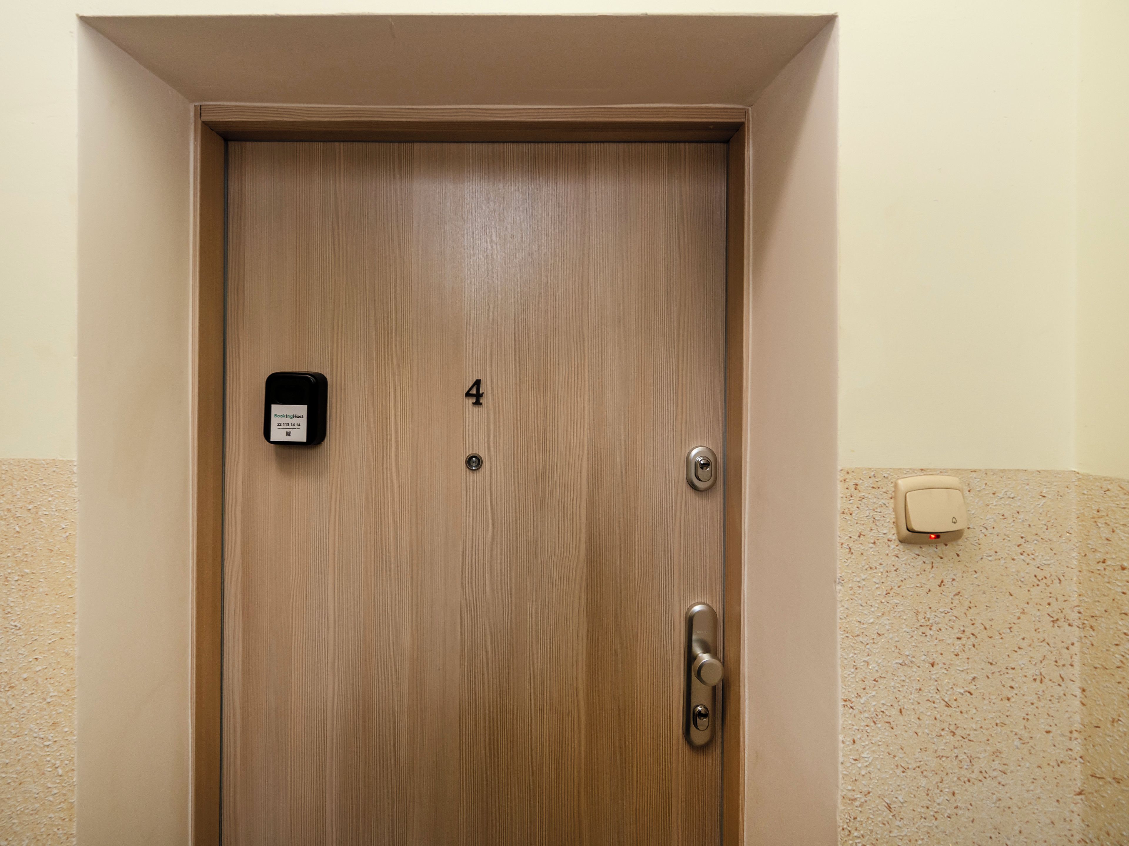 A wooden door with a number '4' and a doorbell.