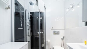 A modern bathroom with a glass-enclosed shower, a toilet, and a sink. - Kopcińskiego Cozy City Studio (Łódź)