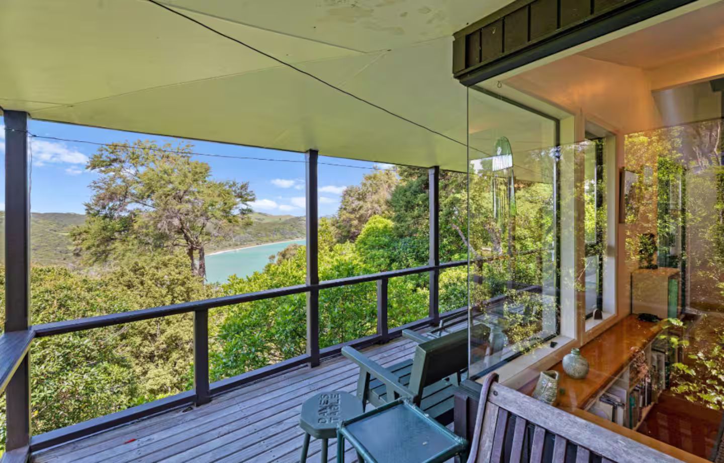Un balcon donnant sur un paysage côtier, avec une table et des chaises.