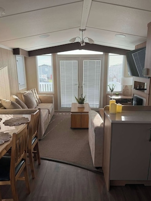 A compact living space with a sofa, dining table, and kitchenette.