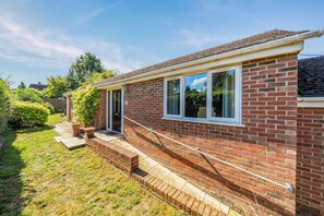 A brick house with a front porch, a small garden, and a clear sky. - One Bed Bungalow Sleeps 4 - Garden - WiFi & Tv (Andover)