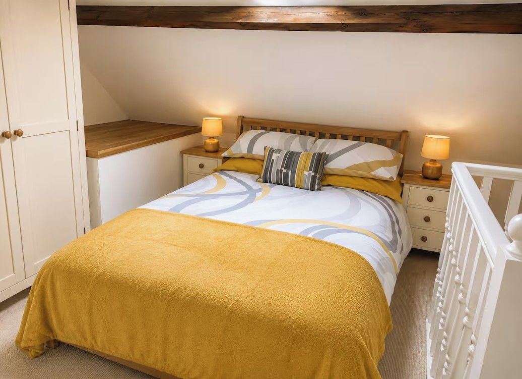 Ein Schlafzimmer mit einem Bett, Nachttischen, einem Wickeltisch und einem Kleiderschrank.