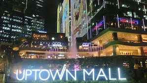 A nighttime view of Uptown Mall with illuminated signage and surrounding buildings. - One Uptown Residence BGC City Living | Fast WiFi + Netflix (Makati City)