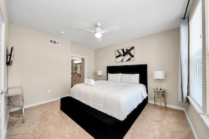 A bedroom with a bed, a ceiling fan, a bedside lamp, and a window with blinds. - luxury 2 kings bedrooms  2 bathrooms woodland (Montgomery)