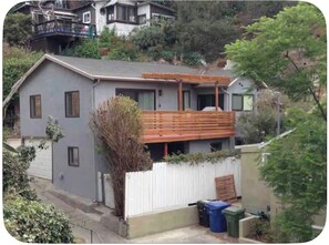 A residential house with a balcony, a garage, and a white fence. - Small Car ONLY Quaint Hillside Studio Apartment 30 day minimum stay. (Los Angeles)