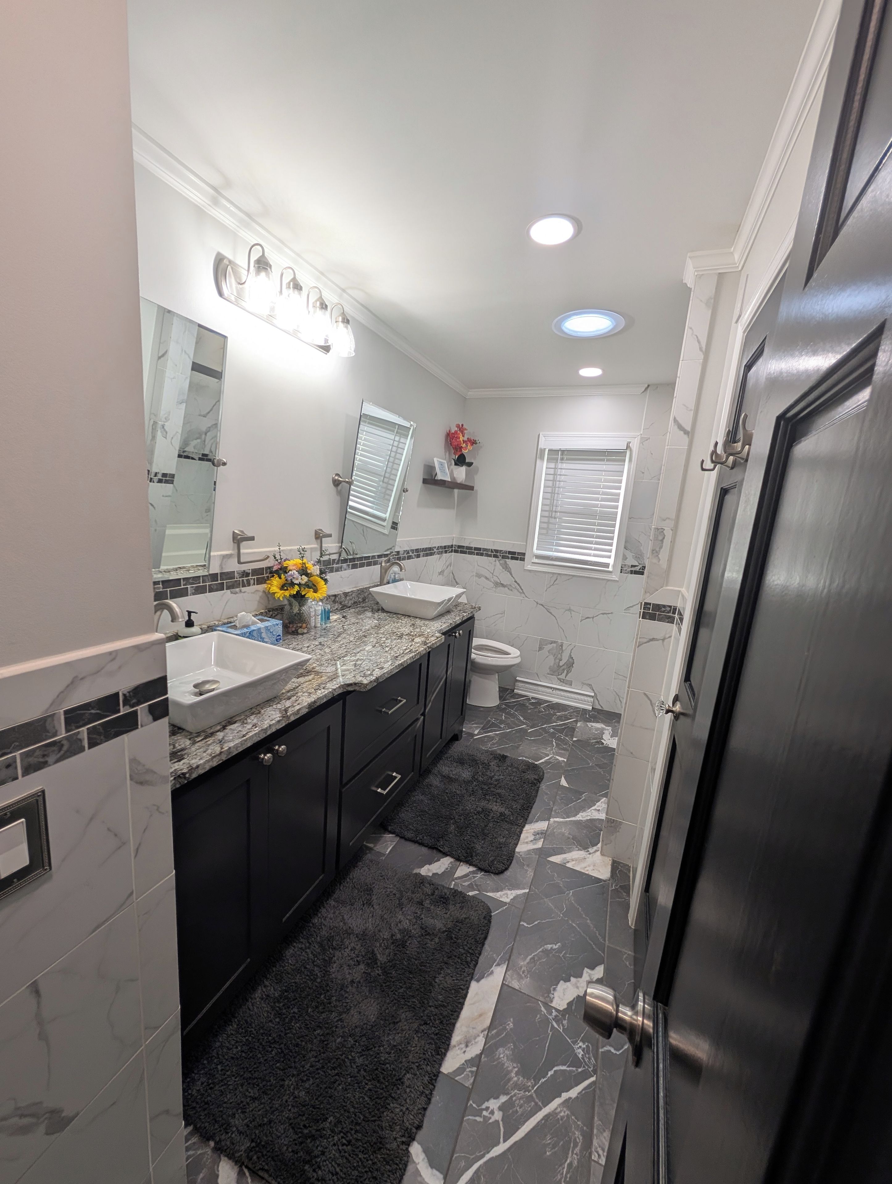 Casa de banho com lavatório duplo, sanita e zona de duche.