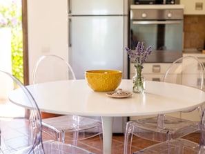 A round white table with a yellow bowl and a clear vase with lavender flowers. - Casa Dell'Ulivo by Interhome (San Teodoro)
