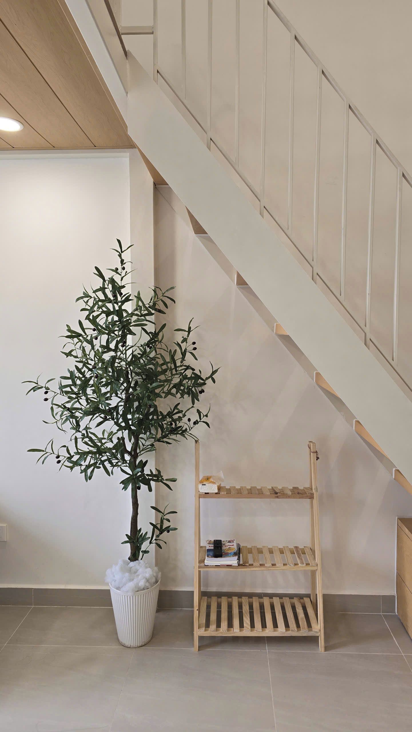 A staircase with a wooden handrail and a white wall.