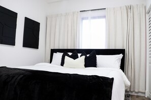 A bedroom with a black headboard, white bedding, and a window with sheer curtains. - Stylish Miami Stay Near Brickell & Downtown (Miami)