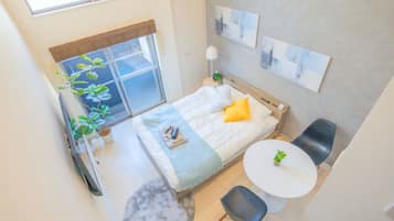 A modern bedroom with a bed, bedside table, and a small round table.