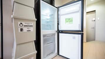 An open refrigerator with a label for 'unburnable cans' and a section for 'plastic bottles.'