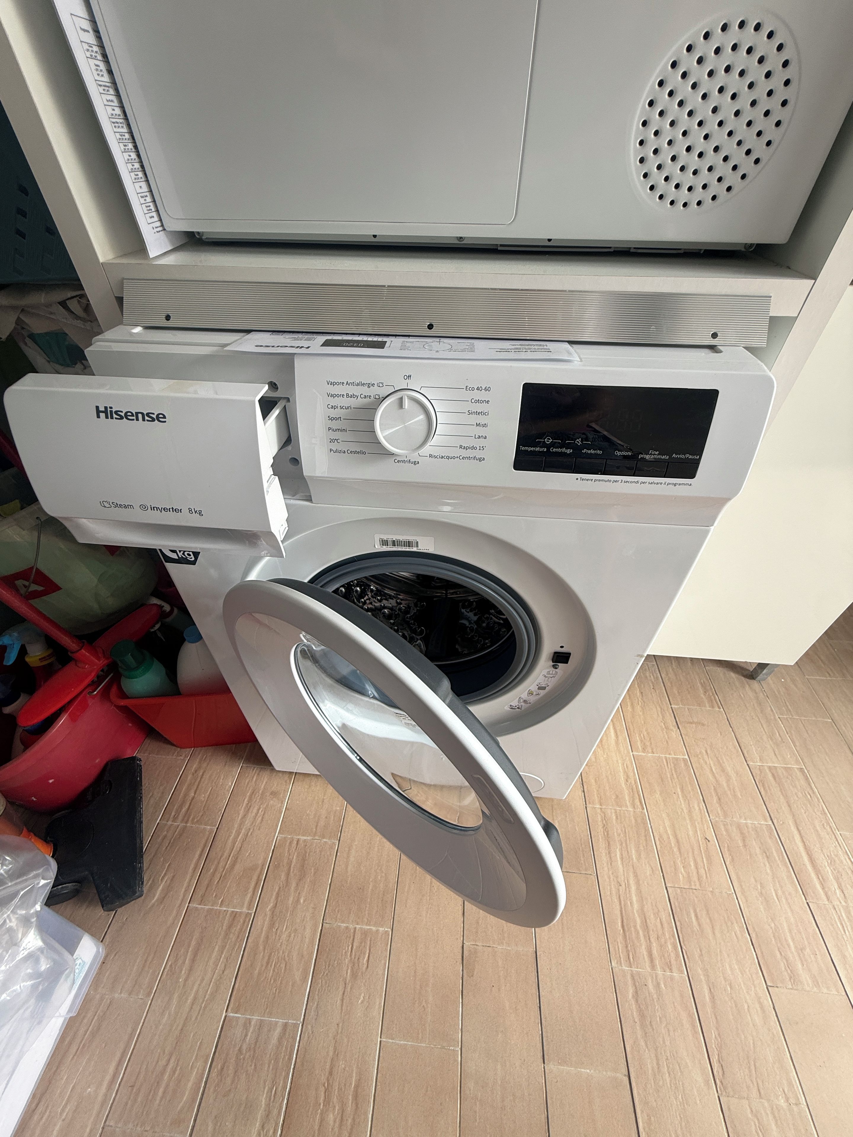 Une machine à laver à chargement frontal dotée d’un panneau de commande, d’un sèche-linge intégré et d’une bouche d’aération en métal située sur le dessus.